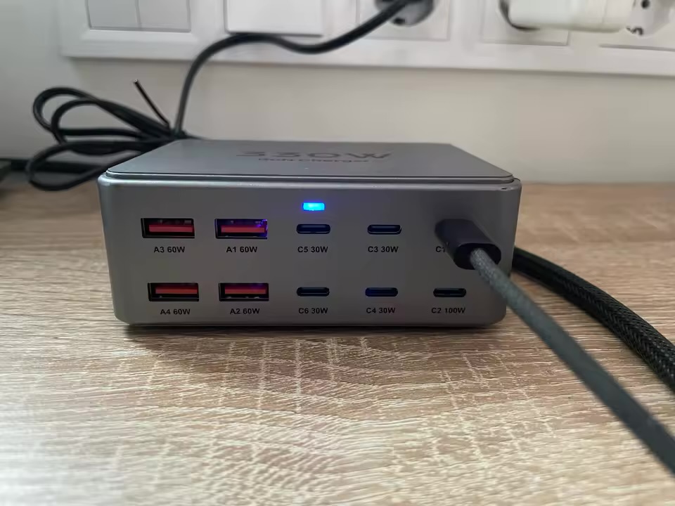 Charging station on a desk showing labelled USB-A and USB-C ports beneath a wall outlet